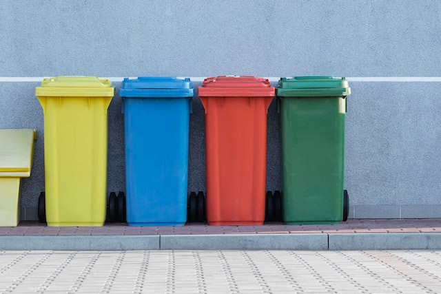different coloured trash bins outside a building