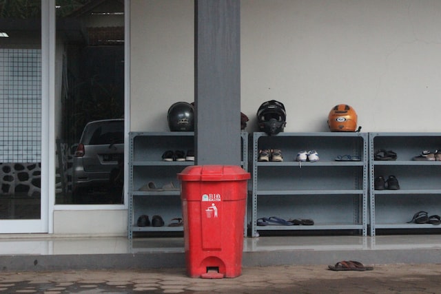 red trash can in front of a school